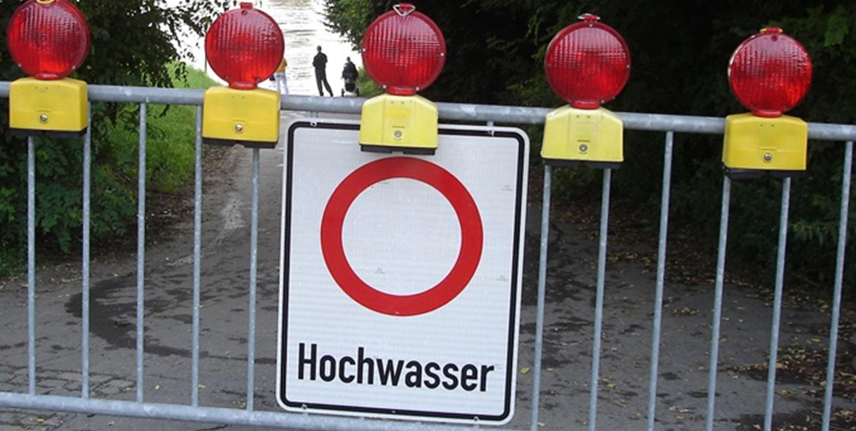 Sperrgitter mit Hochwasser-Warnschild 