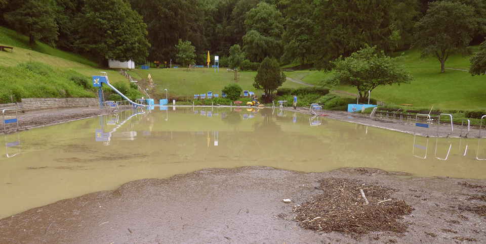 Das Freibad in Eningen unter Achalm mit Schlamm und Treibgut nach einem Starkregenereignis